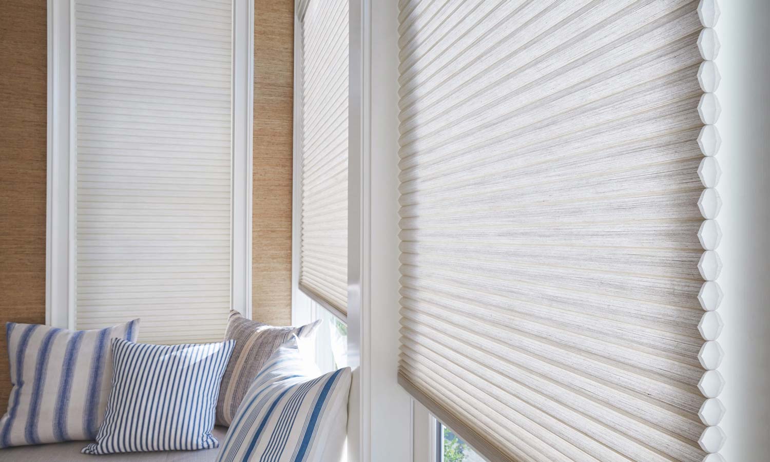 blue honeycomb shades on a window overlooking the ocean