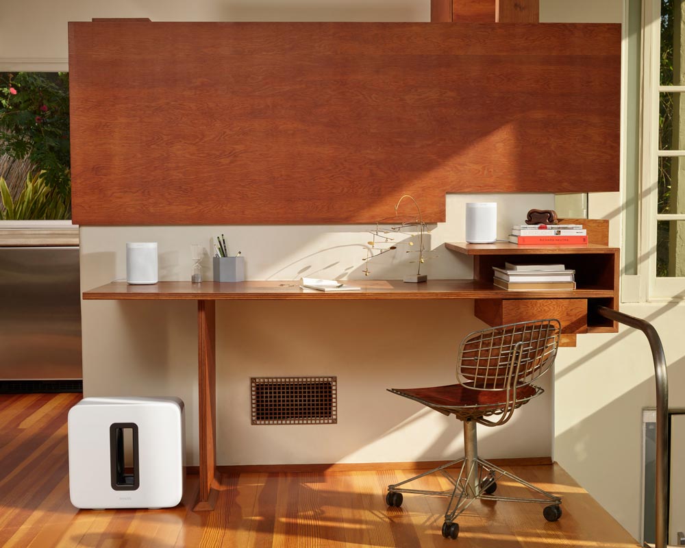 Desk with an office chair and a sonos speaker on the floor