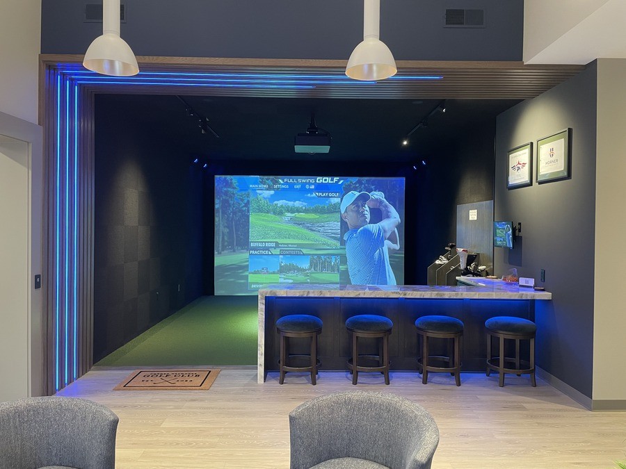 A golf simulator with an image of Tiger Woods and golf courses.